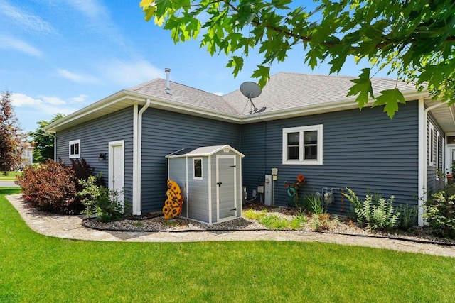 805 Mourning Dove Dr, Cottage Grove, WI 53527 - rear view of house with a lawn, a storage unit, and a shingled roof