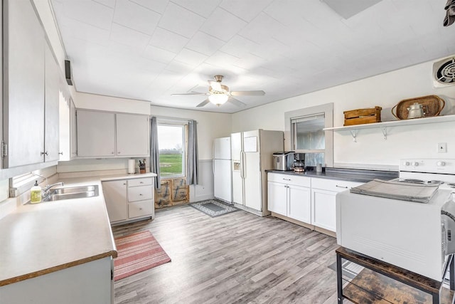 3265 County Road C, Oconto Falls, WI 54154 - kitchen with range with electric cooktop, white fridge with ice dispenser, a ceiling fan, a sink, and light wood-style floors