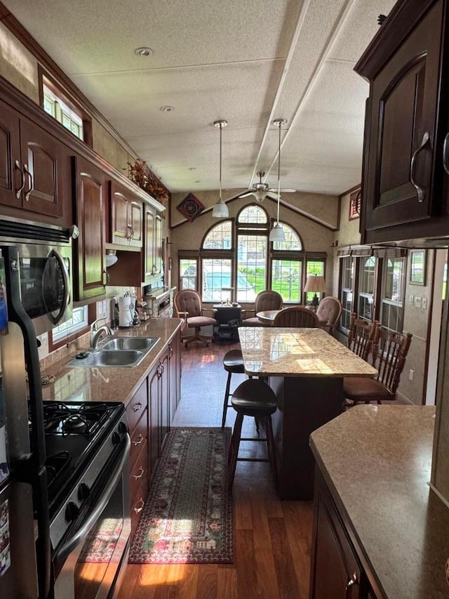 463 Aspen Way, Edgerton, WI 53534 - kitchen featuring stainless steel appliances, dark wood-style floors, a sink, dark brown cabinets, and pendant lighting