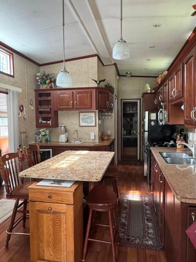 463 Aspen Way, Edgerton, WI 53534 - kitchen with dark wood-style flooring, a sink, a breakfast bar, a kitchen island, and ornamental molding