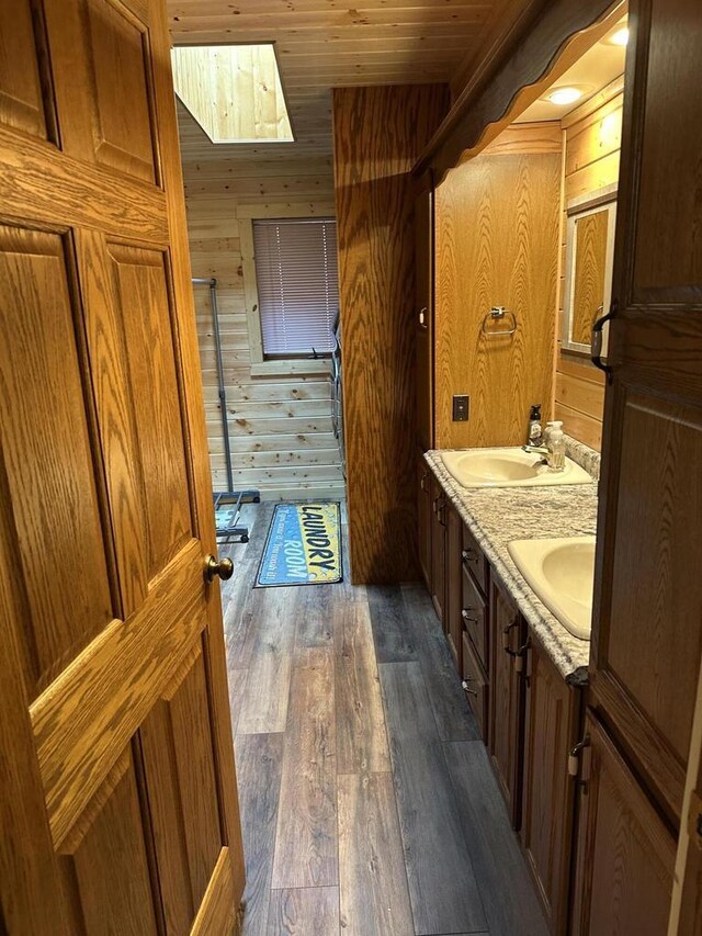 N11894 E Deer Lake Rd, Tomahawk, WI 54487 - bathroom with wooden walls, a shower stall, wood finished floors, double vanity, and wooden ceiling