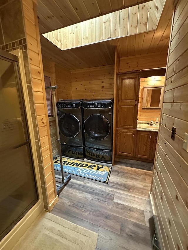 N11894 E Deer Lake Rd, Tomahawk, WI 54487 - clothes washing area with wood ceiling, separate washer and dryer, light wood-style floors, wooden walls, and a skylight