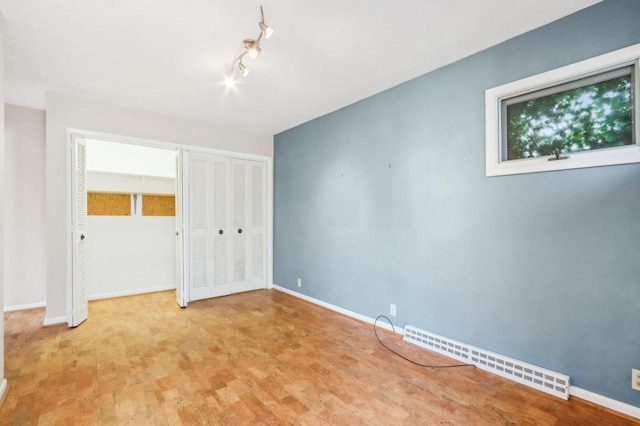 7700 3rd Ave, Kenosha, WI 53143 - unfurnished bedroom featuring a baseboard radiator, multiple closets, and baseboards