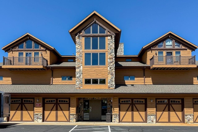1833 20th Ct Unit 1805, Arkdale, WI 54613 - townhome / multi-family property with a balcony, a garage, stone siding, and a shingled roof