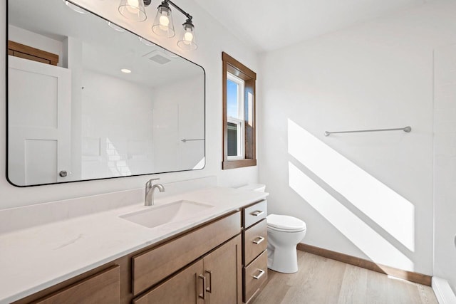 4551 Menasha Ave, Manitowoc, WI 54220 - bathroom featuring wood finished floors, toilet, vanity, and baseboards