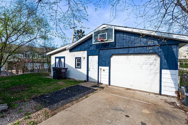 view of side of home with an outdoor structure, driveway, a detached garage, and a lawn