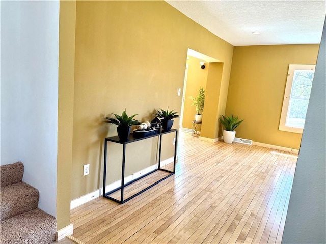 208 N 7th St, Cameron, WI 54822 - corridor with wood-type flooring, baseboards, stairs, and a textured ceiling