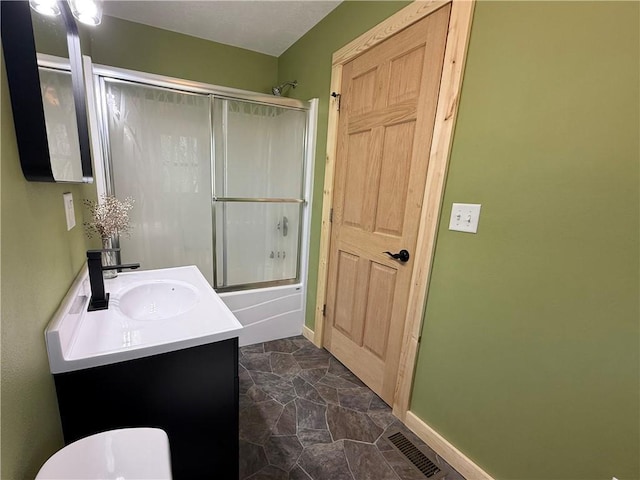 208 N 7th St, Cameron, WI 54822 - full bathroom with bath / shower combo with glass door, vanity, baseboards, and toilet