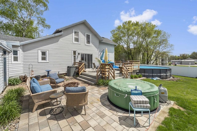 1301 Jackson St, Stoughton, WI 53589 - back of property with an outdoor fire pit, central air condition unit, a deck, a yard, and a patio area
