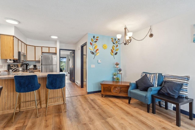 1093 Canyon Rd Unit 603, Wisconsin Dells, WI 53965 - kitchen with stainless steel appliances, a peninsula, light wood finished floors, a chandelier, and light countertops