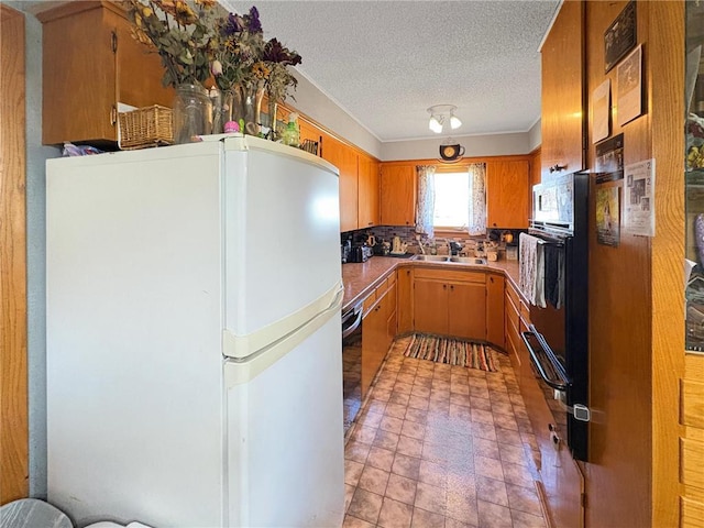 501 S 8th St, Luck, WI 54853 - kitchen featuring freestanding refrigerator, a textured ceiling, oven, a sink, and dishwashing machine