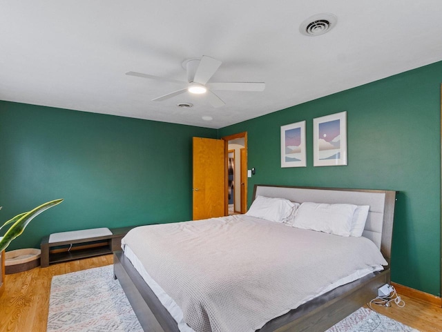 bedroom featuring wood finished floors, ceiling fan, and baseboards