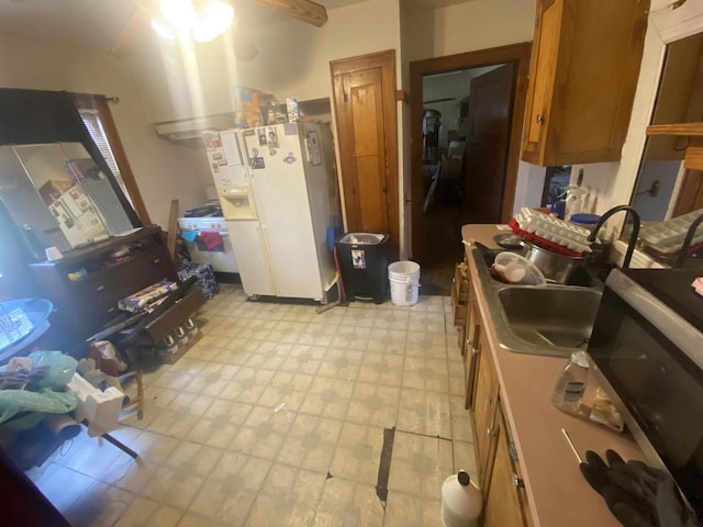kitchen featuring white refrigerator with ice dispenser, stainless steel microwave, brown cabinets, light flooring, and ceiling fan