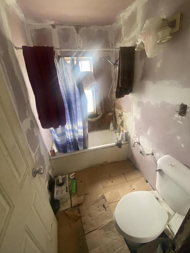 bathroom featuring shower / tub combo with curtain and toilet