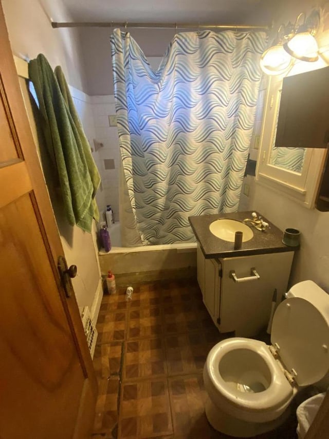 bathroom featuring toilet, shower / tub combo, and vanity