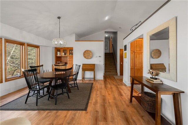 29825 Minerva Cir, Danbury, WI 54830 - dining area featuring lofted ceiling, stairs, light wood-style flooring, a chandelier, and baseboards