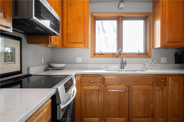 29825 Minerva Cir, Danbury, WI 54830 - kitchen featuring stainless steel appliances, a sink, brown cabinets, and light countertops