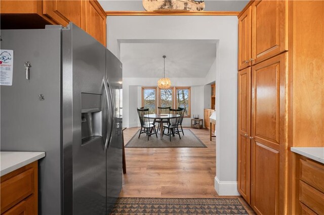 29825 Minerva Cir, Danbury, WI 54830 - kitchen with stainless steel fridge, light wood-style flooring, brown cabinetry, and vaulted ceiling