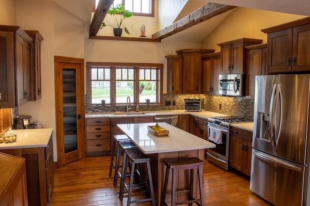 953 Larkspur Rd, Plymouth, WI 53073 - kitchen with stainless steel appliances, tasteful backsplash, a breakfast bar, dark wood finished floors, and light countertops
