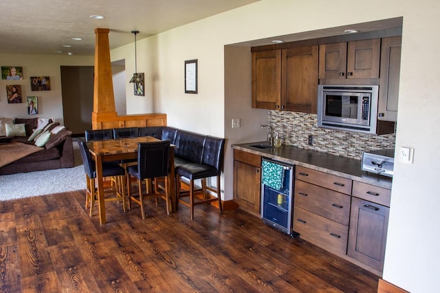 953 Larkspur Rd, Plymouth, WI 53073 - kitchen featuring wine cooler, dark wood-type flooring, open floor plan, decorative backsplash, and a sink