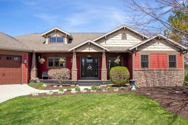 953 Larkspur Rd, Plymouth, WI 53073 - craftsman-style home with stone siding, a front lawn, concrete driveway, a garage, and covered porch