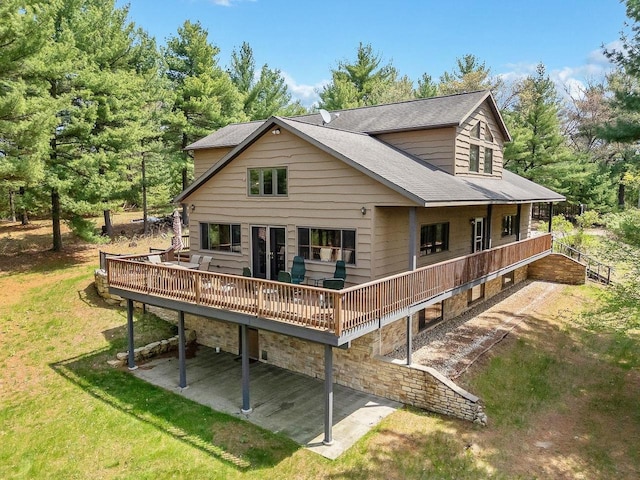 E9510 Oak Hill Rd, Wisconsin Dells, WI 53965 - rear view of house featuring a wooden deck, a patio area, a lawn, and roof with shingles