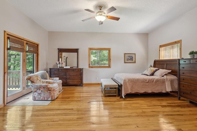 E9510 Oak Hill Rd, Wisconsin Dells, WI 53965 - bedroom featuring access to exterior, light wood-type flooring, a textured ceiling, ceiling fan, and baseboards