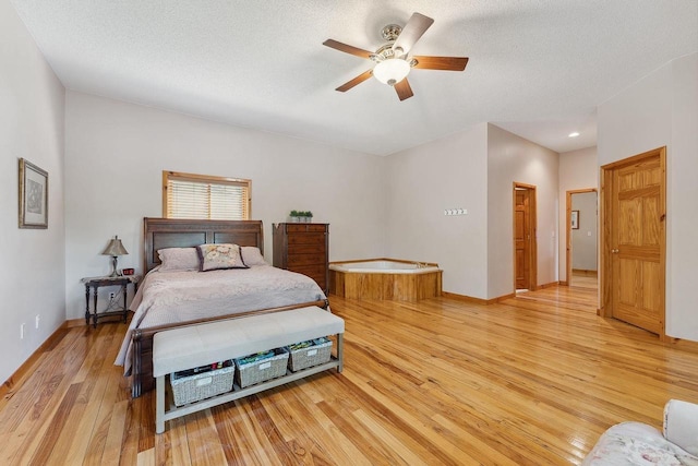 E9510 Oak Hill Rd, Wisconsin Dells, WI 53965 - bedroom with light wood-style floors, baseboards, a ceiling fan, a textured ceiling, and recessed lighting