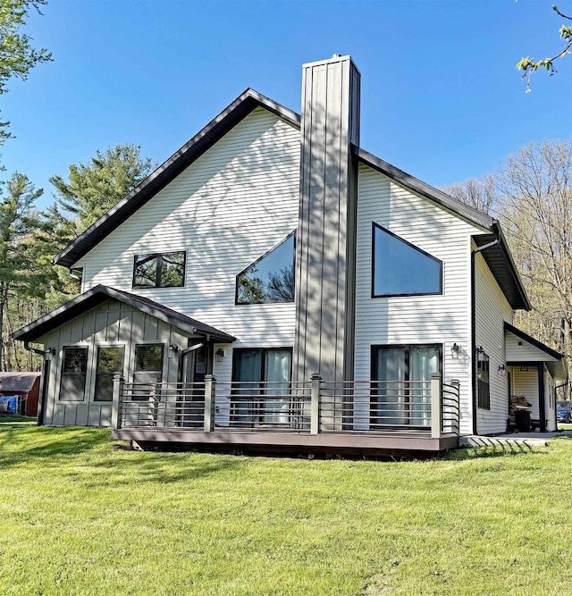 S952 W Redstone Dr, La Valle, WI 53941 - rear view of house with a chimney, a lawn, board and batten siding, and a deck