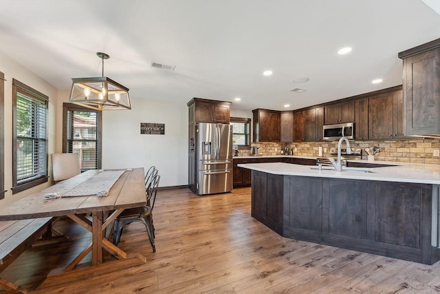 S952 W Redstone Dr, La Valle, WI 53941 - kitchen with appliances with stainless steel finishes, dark brown cabinetry, healthy amount of natural light, tasteful backsplash, and recessed lighting