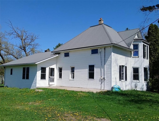 N34855 County Rd S, Blair, WI 54616 - rear view of house with a chimney, a lawn, and metal roof