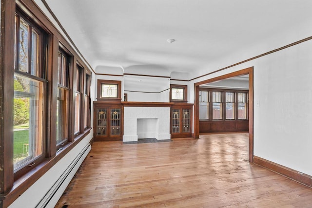 2535 N 48th St, Milwaukee, WI 53210 - unfurnished living room featuring a baseboard heating unit, healthy amount of natural light, light wood-type flooring, and a fireplace