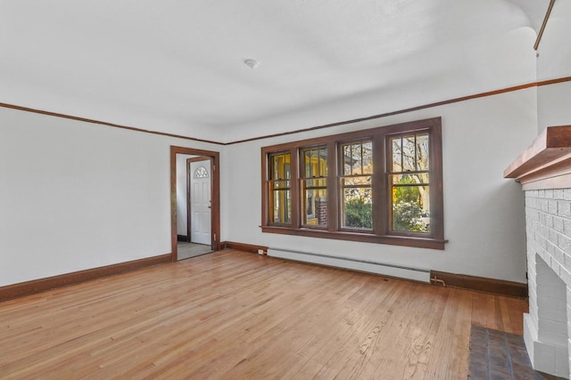 2535 N 48th St, Milwaukee, WI 53210 - unfurnished living room featuring a baseboard heating unit, a fireplace, baseboards, and light wood-style flooring