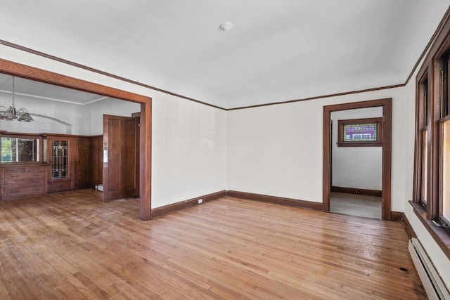 2535 N 48th St, Milwaukee, WI 53210 - unfurnished room with a baseboard heating unit, a chandelier, light wood-style floors, baseboards, and crown molding