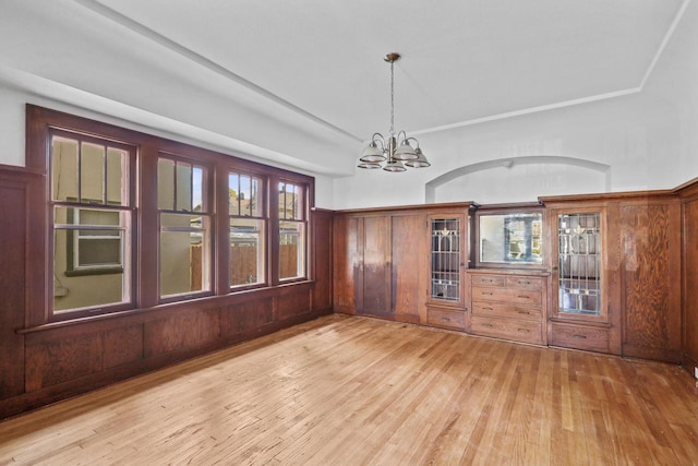 2535 N 48th St, Milwaukee, WI 53210 - unfurnished dining area with a chandelier, light wood finished floors, and wooden walls