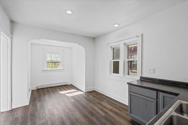 2535 N 48th St, Milwaukee, WI 53210 - unfurnished dining area with baseboard heating, dark wood finished floors, recessed lighting, baseboards, and arched walkways