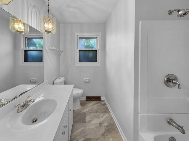 4538 Oakdale Dr, Racine, WI 53405 - full bath featuring vanity, shower / tub combination, baseboards, and toilet