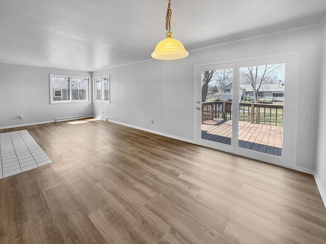 4538 Oakdale Dr, Racine, WI 53405 - unfurnished living room featuring wood finished floors, healthy amount of natural light, and baseboard heating