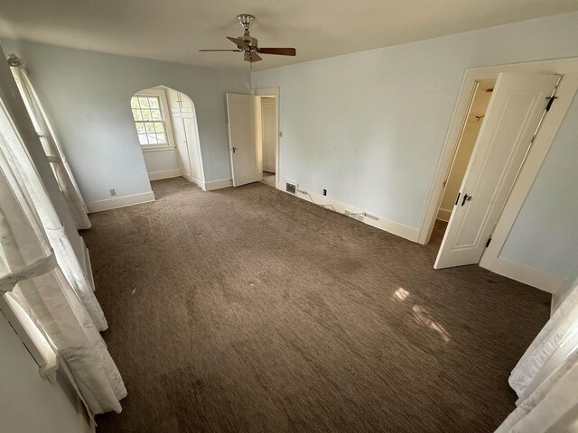 1263 N Parker Dr, Janesville, WI 53545 - unfurnished bedroom featuring carpet flooring, arched walkways, baseboards, and a ceiling fan
