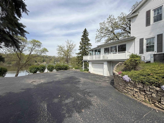 1263 N Parker Dr, Janesville, WI 53545 - view of side of home featuring asphalt driveway, a balcony, and a garage