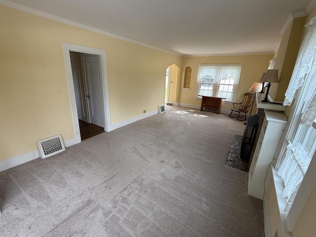 1263 N Parker Dr, Janesville, WI 53545 - unfurnished living room featuring arched walkways, carpet flooring, crown molding, and baseboards