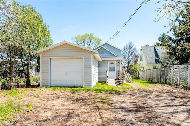 garage with fence and driveway
