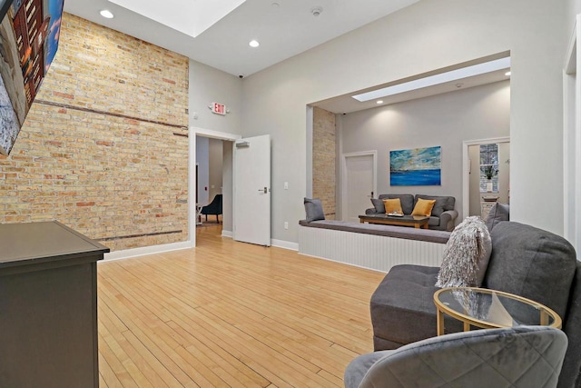 9302 39th Ave, Pleasant Prairie, WI 53158 - sitting room featuring a high ceiling, a skylight, light wood-style floors, baseboards, and brick wall