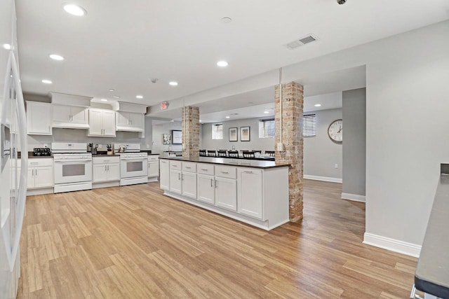 9302 39th Ave, Pleasant Prairie, WI 53158 - kitchen with white range with gas stovetop, ornate columns, dark countertops, light wood-type flooring, and recessed lighting