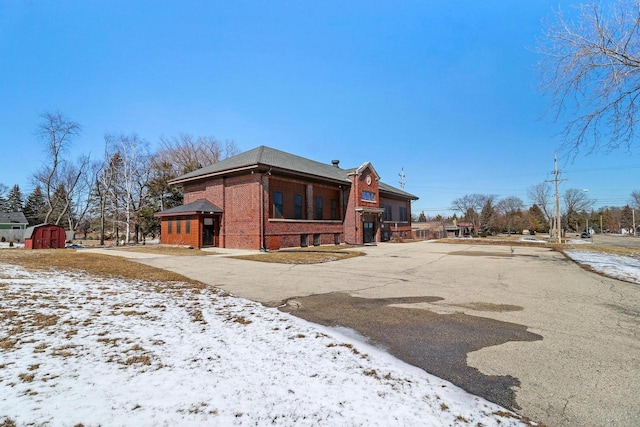 9302 39th Ave, Pleasant Prairie, WI 53158 - snow covered back of property with brick siding, a shed, and an outdoor structure