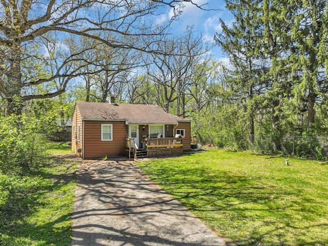 view of front of property with a deck, asphalt driveway, and a chimney