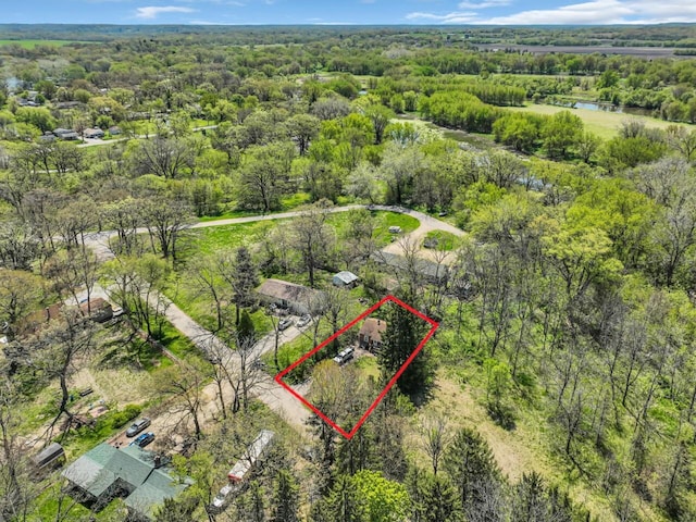 aerial overview of property's location featuring a heavily wooded area, property boundaries highlighted, and a nearby body of water