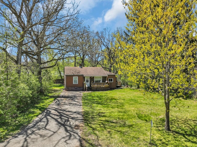 view of front of home featuring driveway, a front lawn, and covered porch