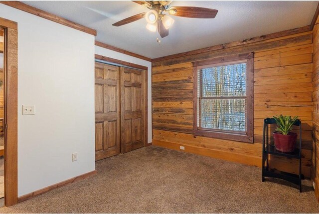 744 50th Ave, Clear Lake, WI 54005 - unfurnished bedroom with wood walls, carpet flooring, baseboards, a ceiling fan, and a closet