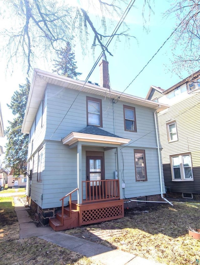 back of property featuring a porch and a chimney